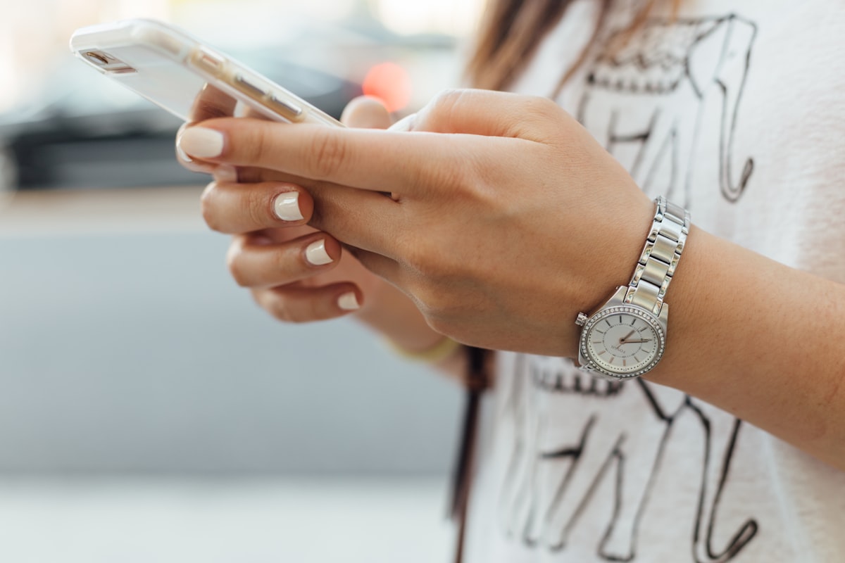 Person holding a smartphone with both hands and using it