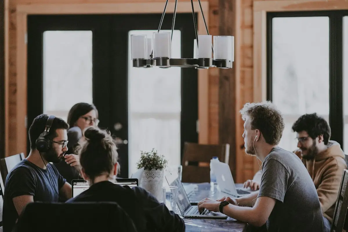 A team working at laptops around a dining table