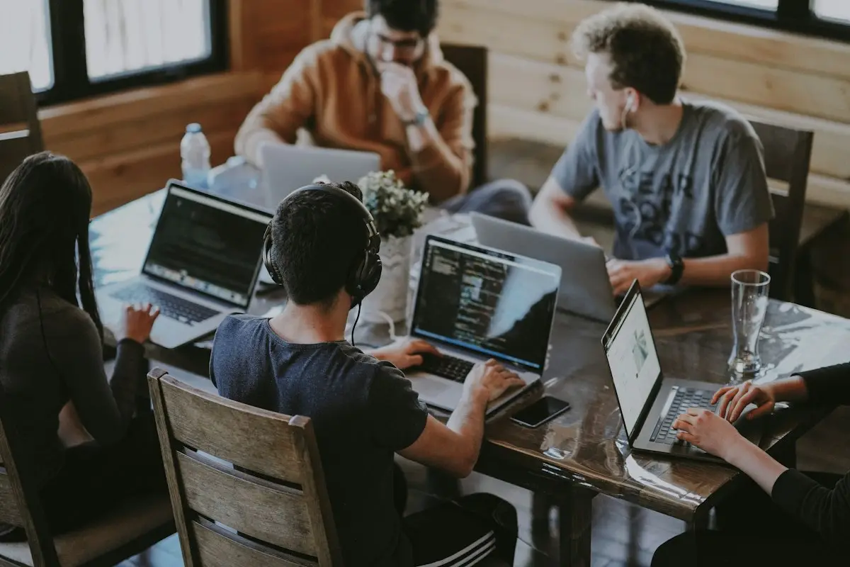 A small team working together at laptops around one table