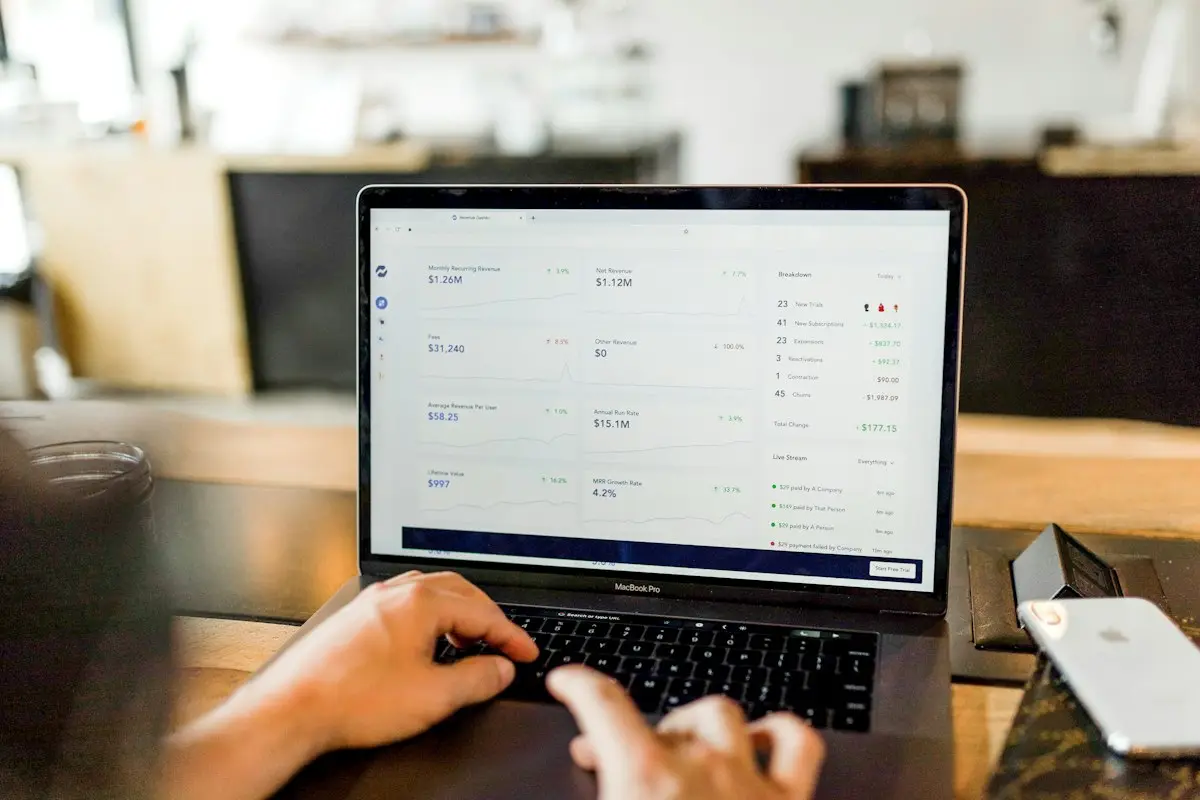 Hands typing on a laptop with a list of messages on screen