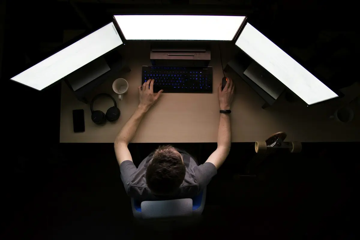 Overhead view of a person at a desk with three monitors