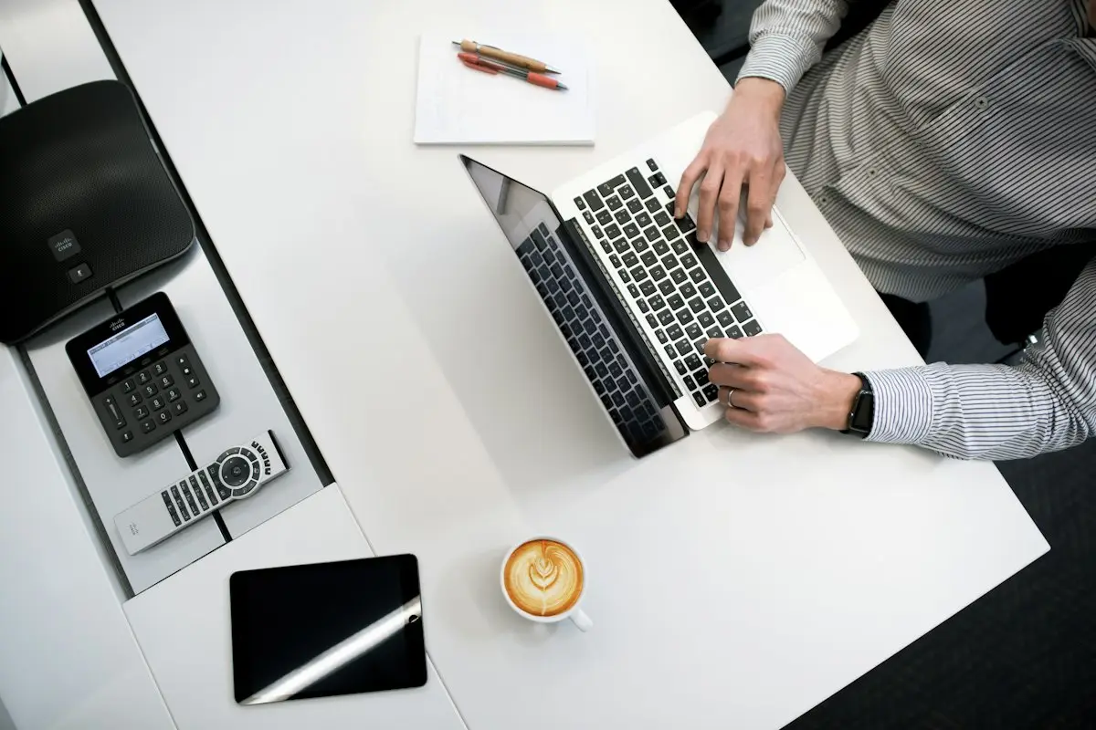 Overhead view of a laptop, a card machine and a coffee