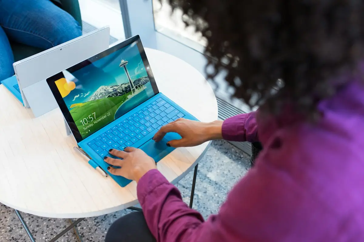 A woman working on a tablet with a keyboard at a cafe table