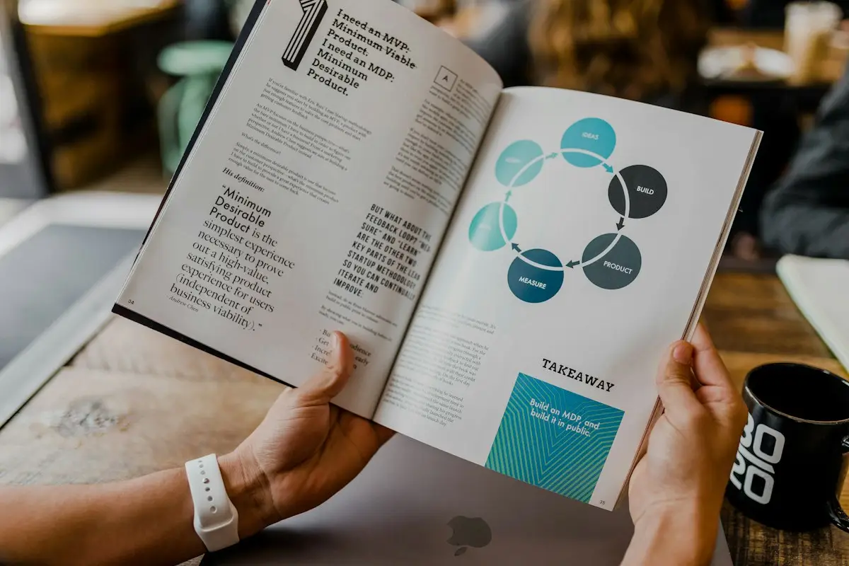 Hands holding an open brochure with a diagram