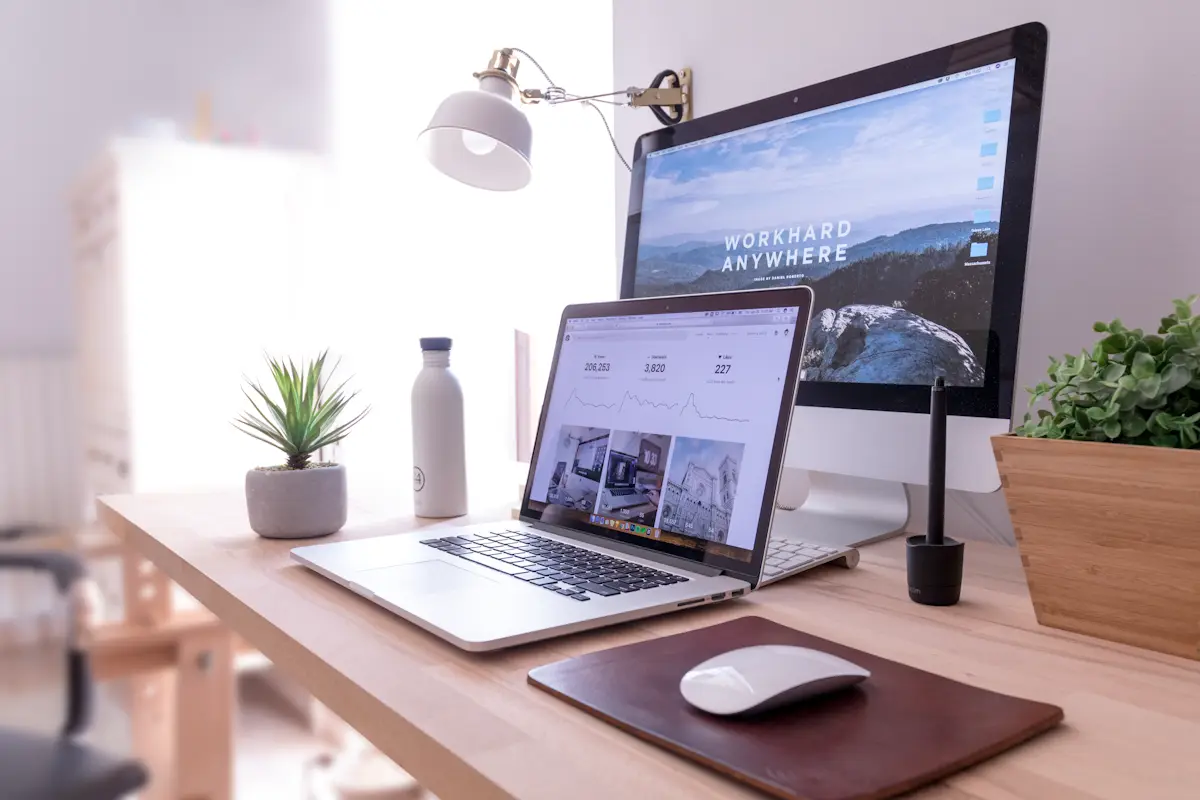 A bright home office desk with a laptop and a monitor