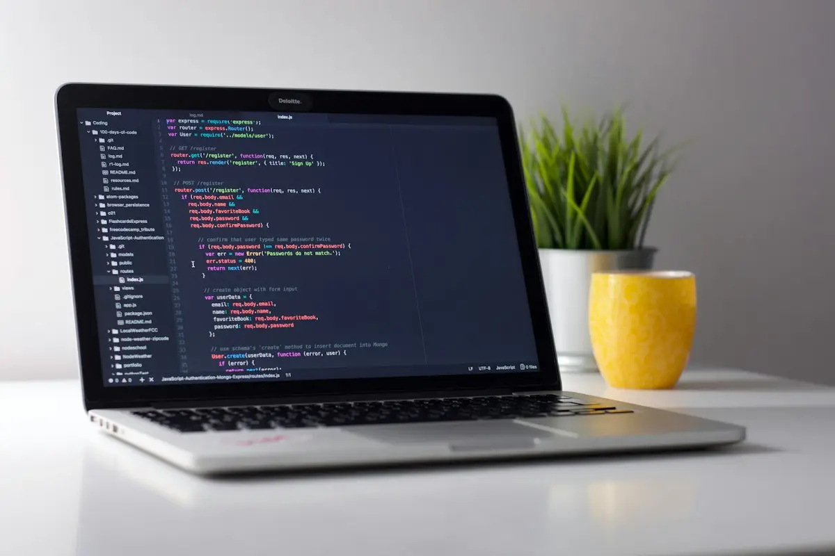 A laptop with code open on a white desk