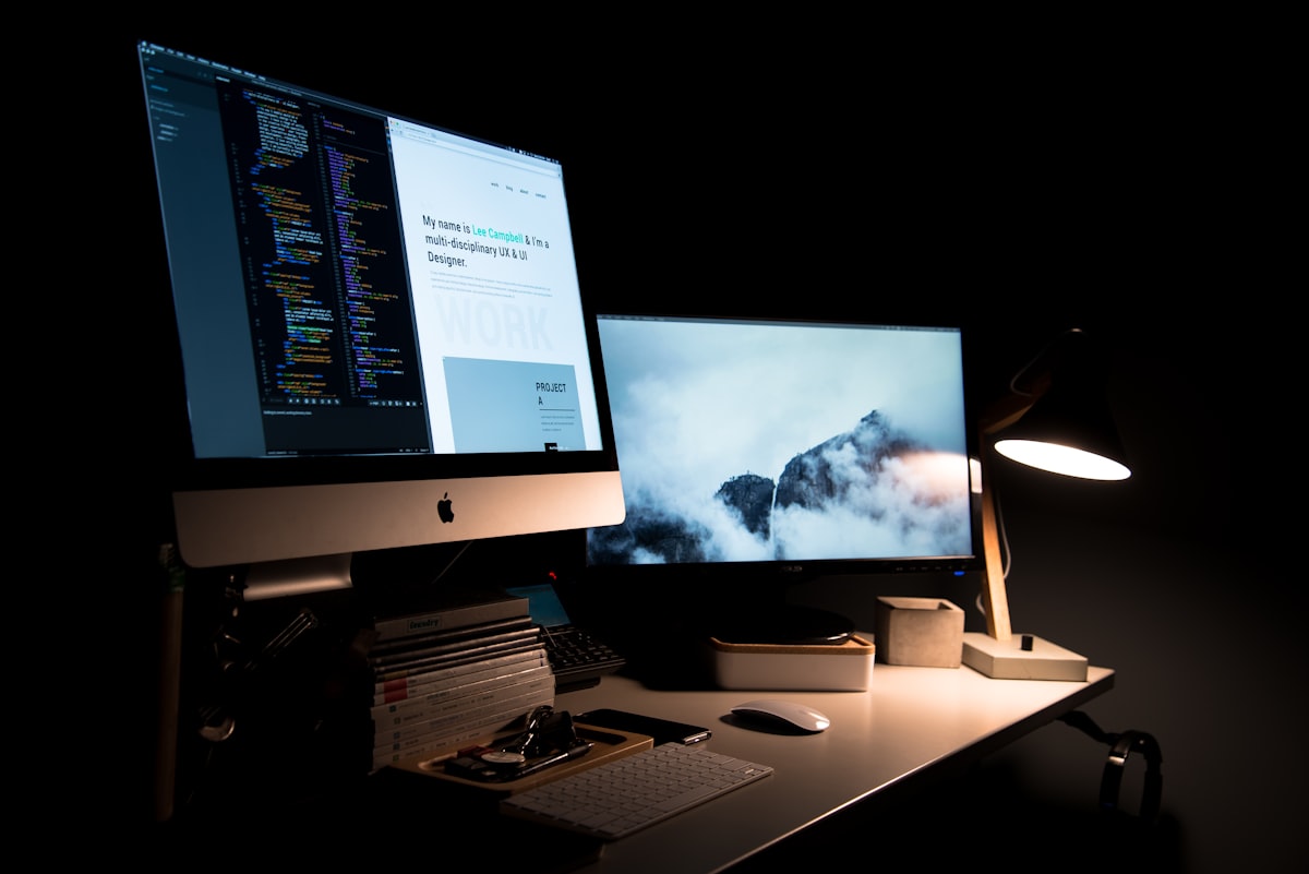 A designer's portfolio website open on a desktop monitor in a dimly lit studio