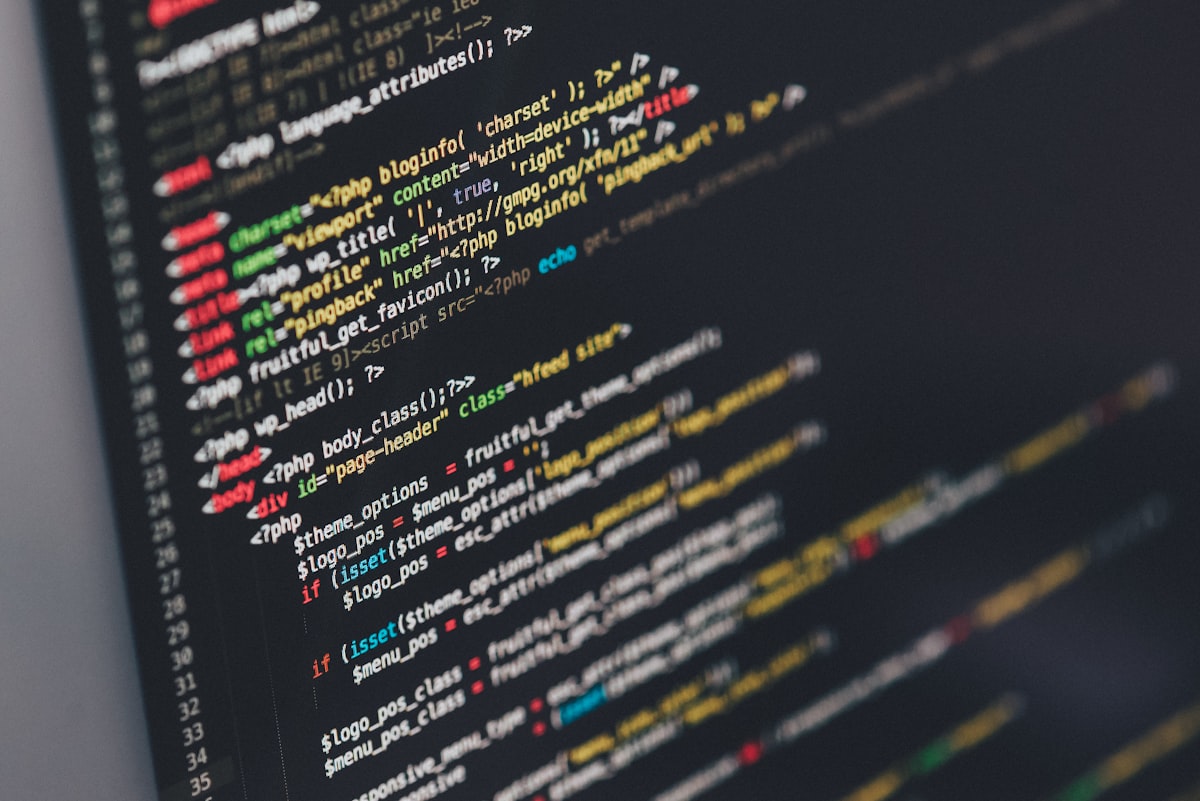 Close-up of a monitor showing colour-highlighted WordPress PHP template code on a dark background